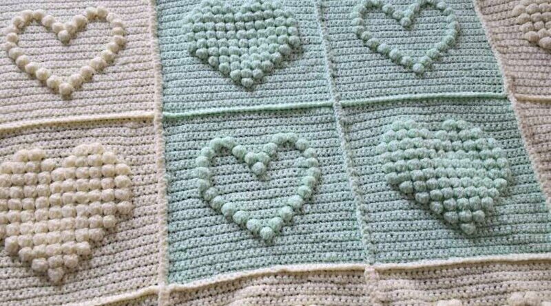 Beautiful Bobble Heart Crochet Blanket in soft pastel yarn, perfect handmade baby blanket pattern with bobble hearts.