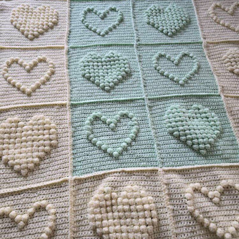 Beautiful Bobble Heart Crochet Blanket in soft pastel yarn, perfect handmade baby blanket pattern with bobble hearts.