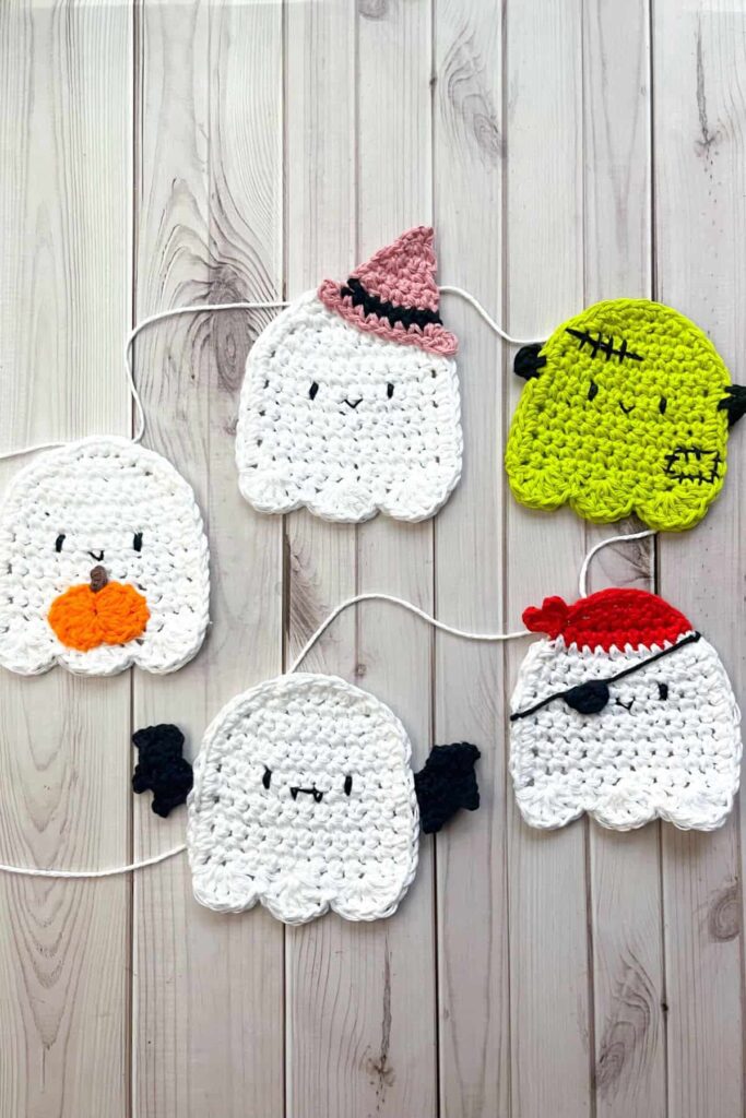 Crochet ghost garland hanging on fireplace, white cotton ghosts Halloween decor"