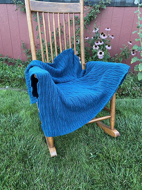 Lightweight crochet blanket with ripple stitch in ocean colors, ideal as a summer throw
