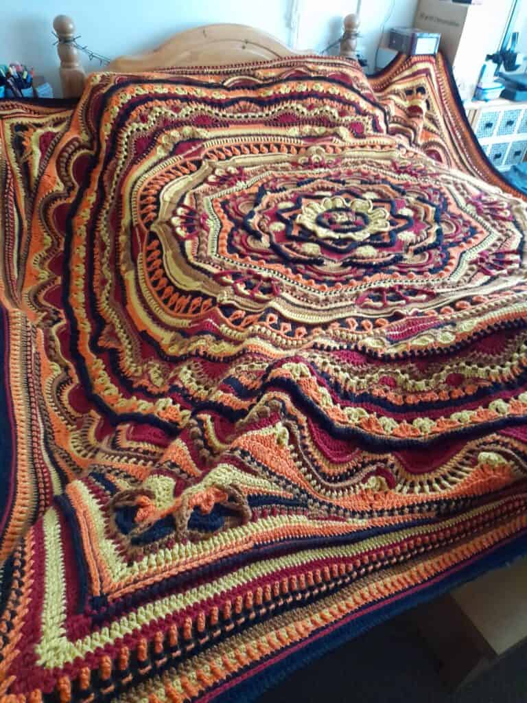Mandala Madness round crochet blanket with yellow, orange and brown tones