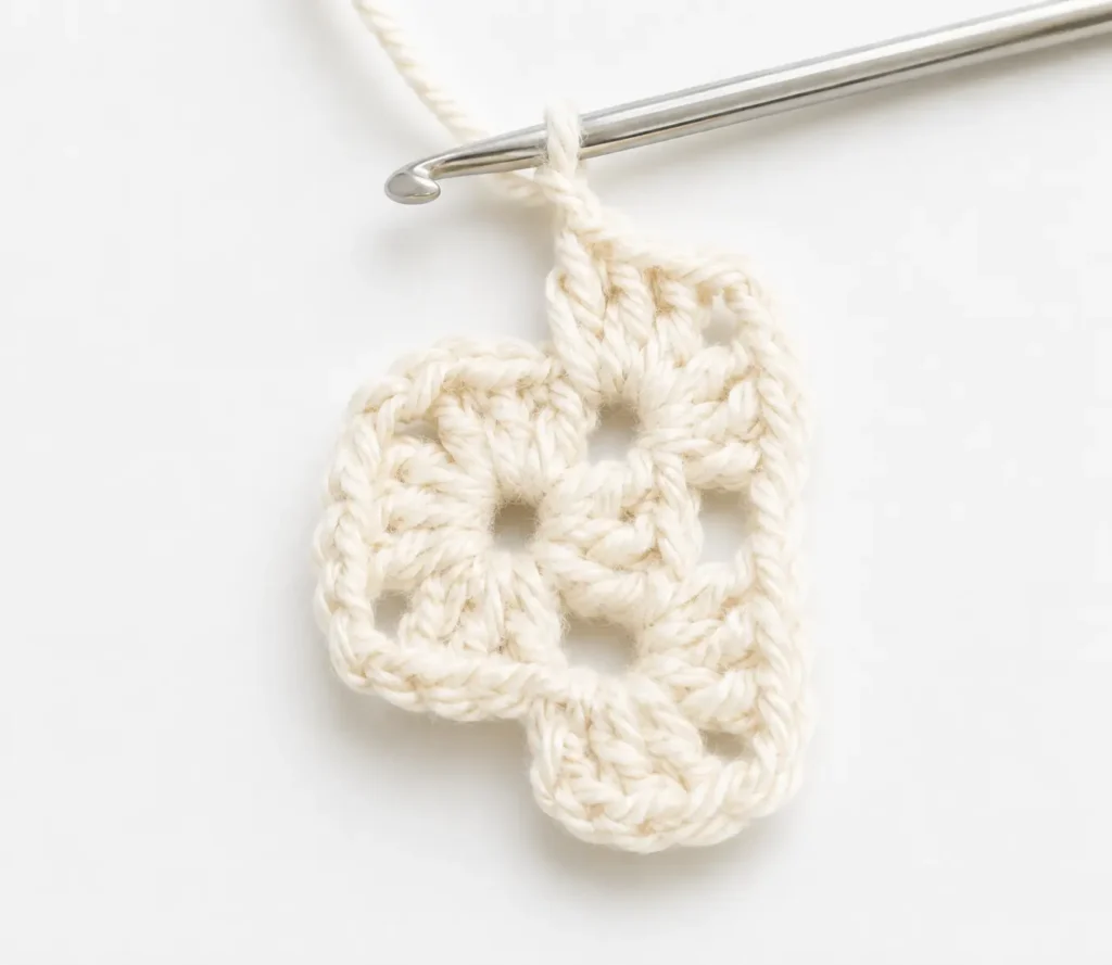 Easy granny square pattern round 2 completed showing corner formation