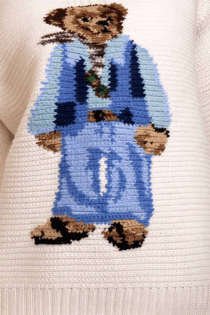Handmade Polo Bear Sweater crochet pattern with a detailed bear motif on an off-white background, modeled in a casual indoor setting.