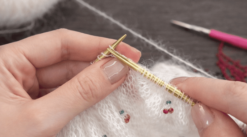 Hand-knitted cherry triangle scarf with chart-based design and clean knitted edges