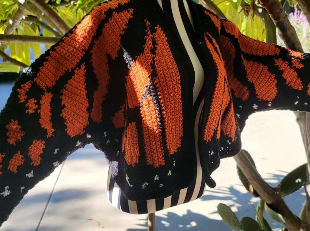 Finished Monarch Butterfly Cardigan crocheted with vibrant yarns displayed on a mannequin
