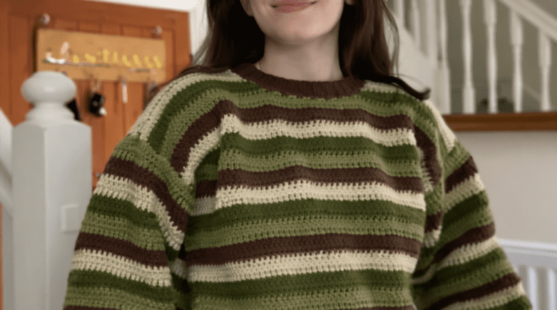 Handmade crochet sweater jumper with horizontal stripes in mustard yellow and cream, featuring textured stitches and relaxed fit, worn by a model outdoors.