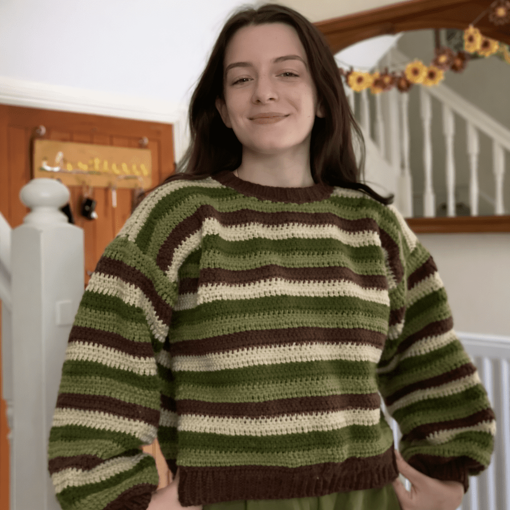 Handmade crochet sweater jumper with horizontal stripes in mustard yellow and cream, featuring textured stitches and relaxed fit, worn by a model outdoors.