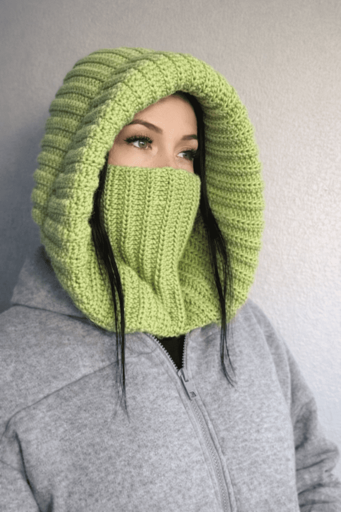 Model wearing a stylish red crochet hood made with a Free Crochet Balaclava Pattern, showcasing the texture and fit of this trendy crochet accessory.