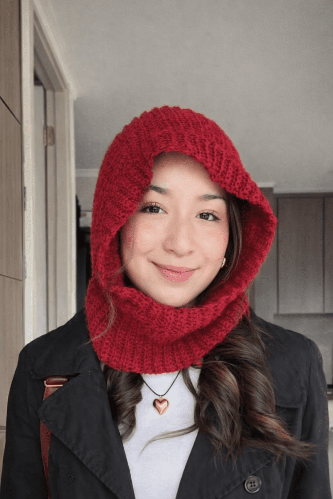 Free Crochet Balaclava Pattern featuring a cozy red crochet hood worn by a woman, showing a modern handmade balaclava style perfect for winter fashion.