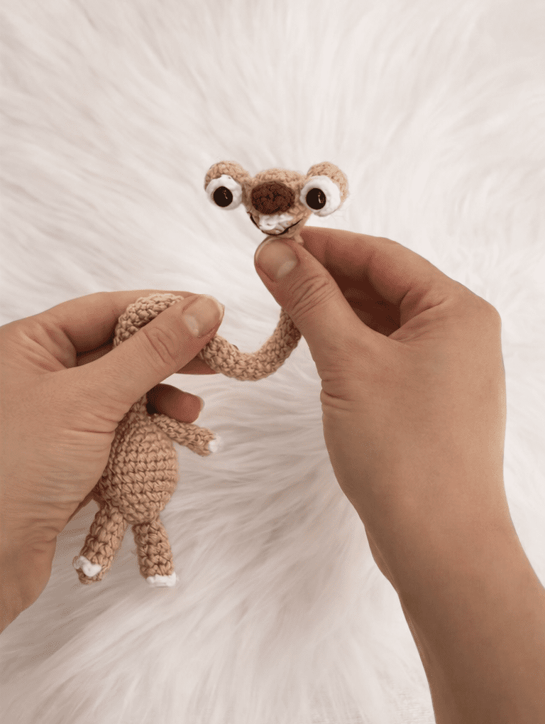 Sid crochet bag keychain inspired by Ice Age, handmade amigurumi sloth with long neck and big eyes, shown as a cute crochet bag charm.