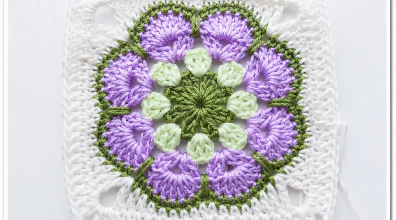 African flower granny square finished showing complete floral motif in pink blue teal and cream